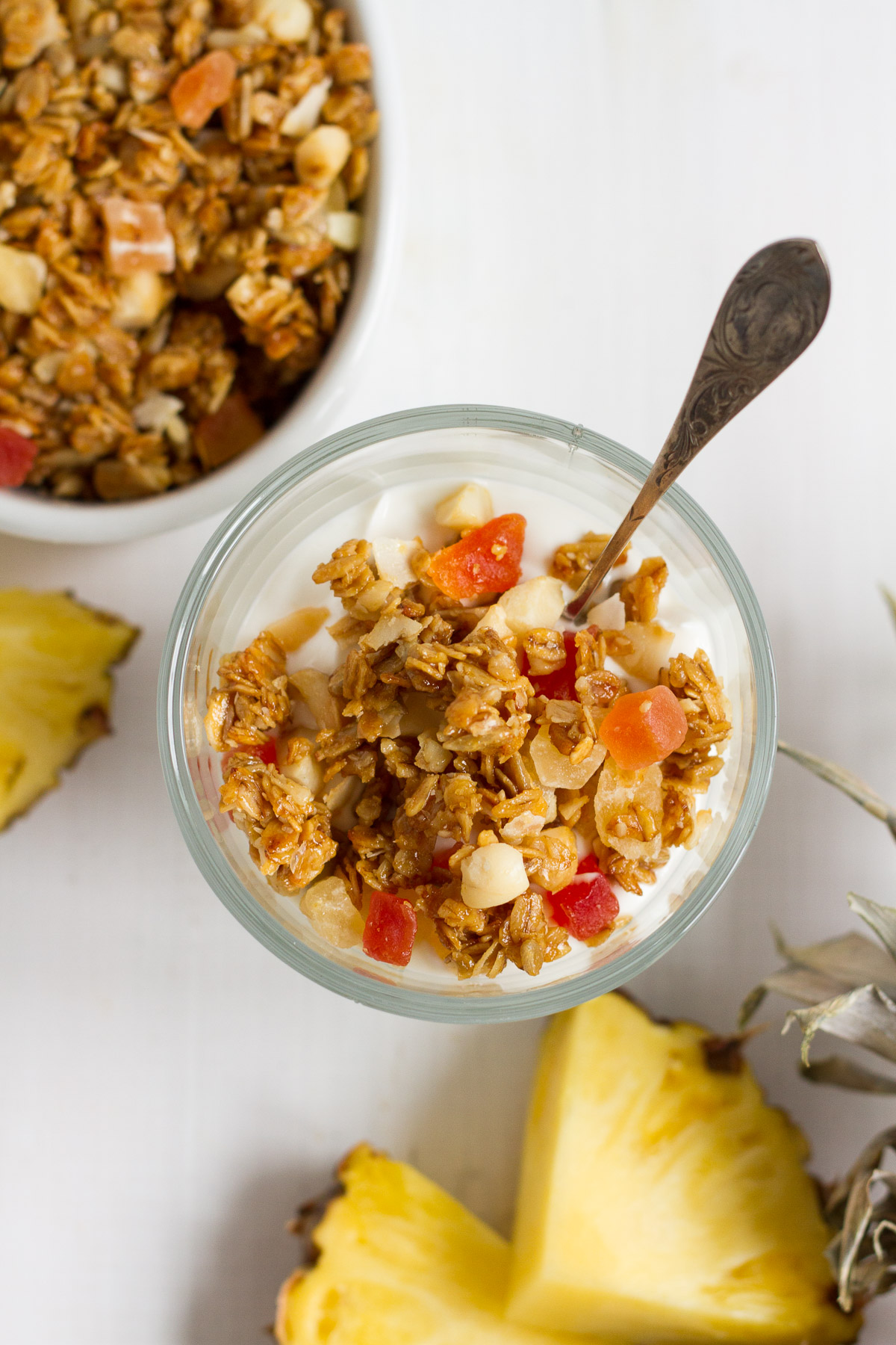 Crunchy homemade granola with oats, sunflower seeds, macadamia nuts, coconut chips, dried tropical fruits likes pineapple, mango, and papaya, lightly sweetened with honey and brown sugar.